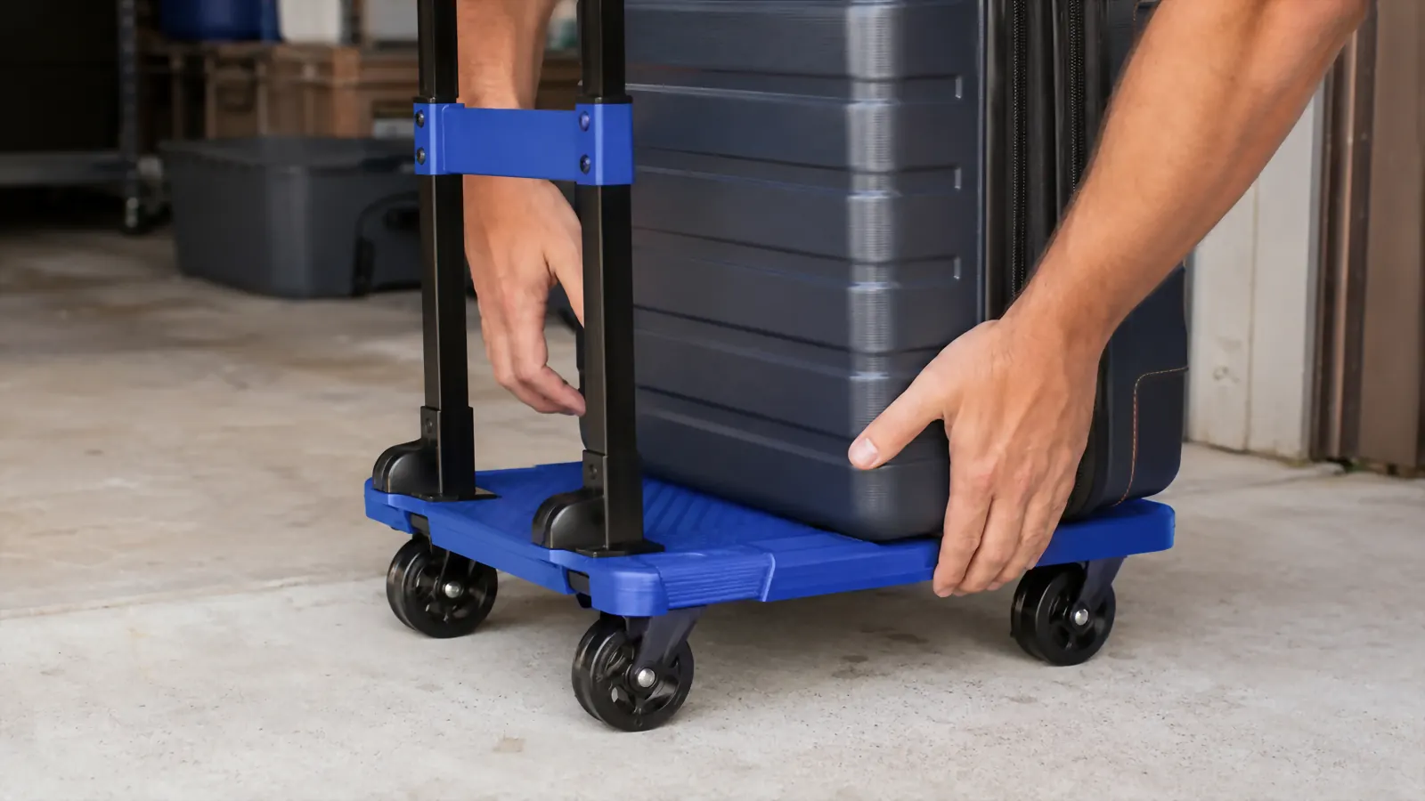 Hand placing the heaviest suitcase flat against the base plate of a folding luggage cart